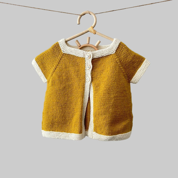 Chloe cardigan in mustard with natural trim on hanger