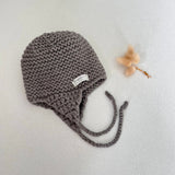 Knitted chunky knit baby hat mushroom colour on a light grey background