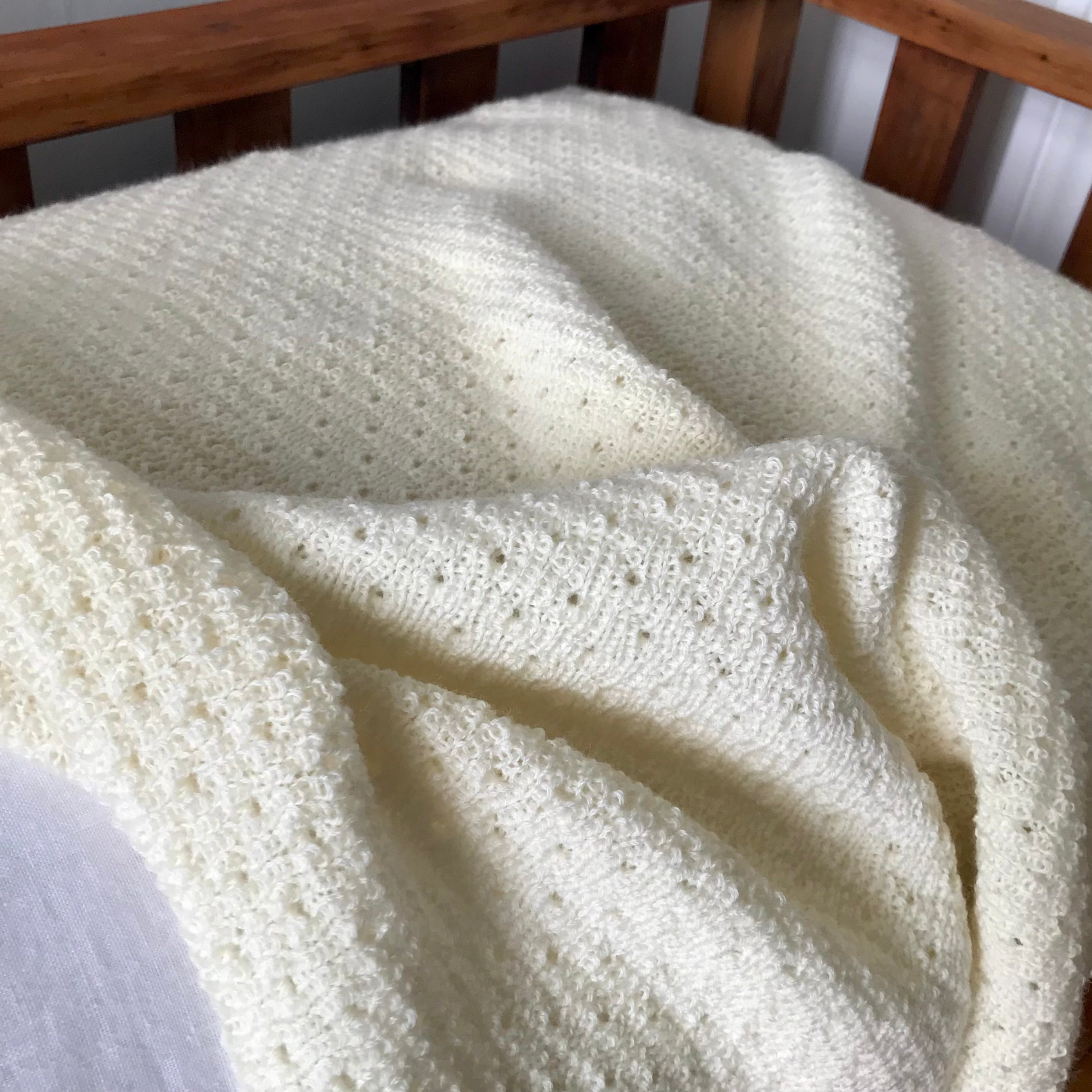 Cream merino baby wrap on cot