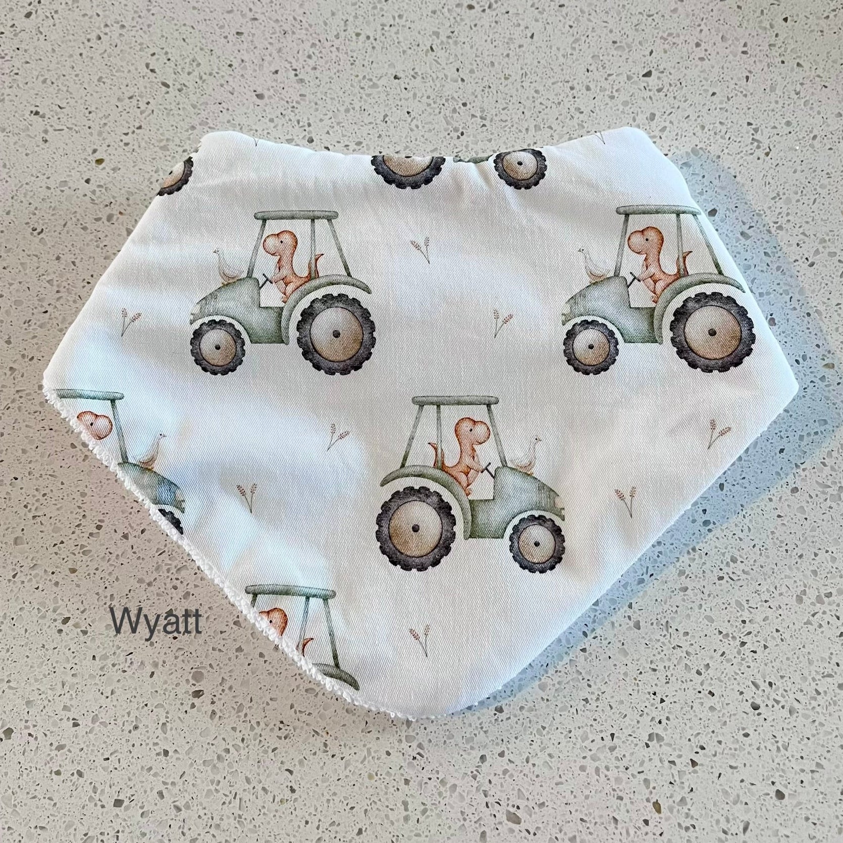 Baby bib with tractor pattern on a textured surface