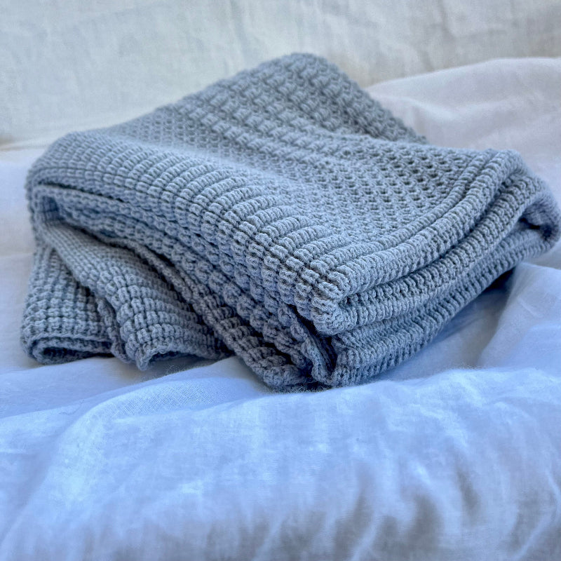 Folded misty blue merino cot blanket nz made