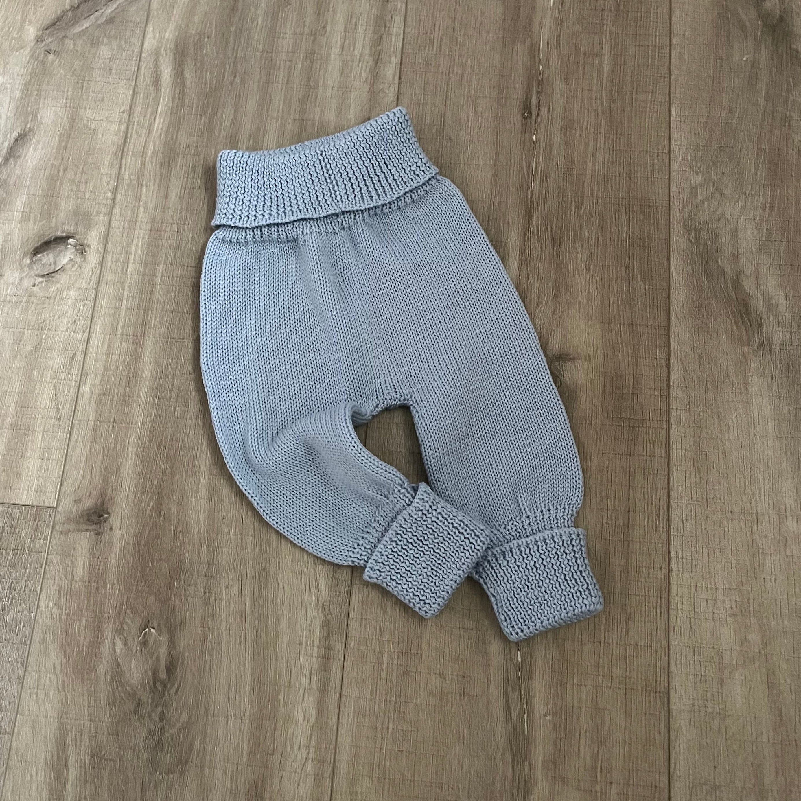 Baby blue colour knitted jodhpurs on wooden surface