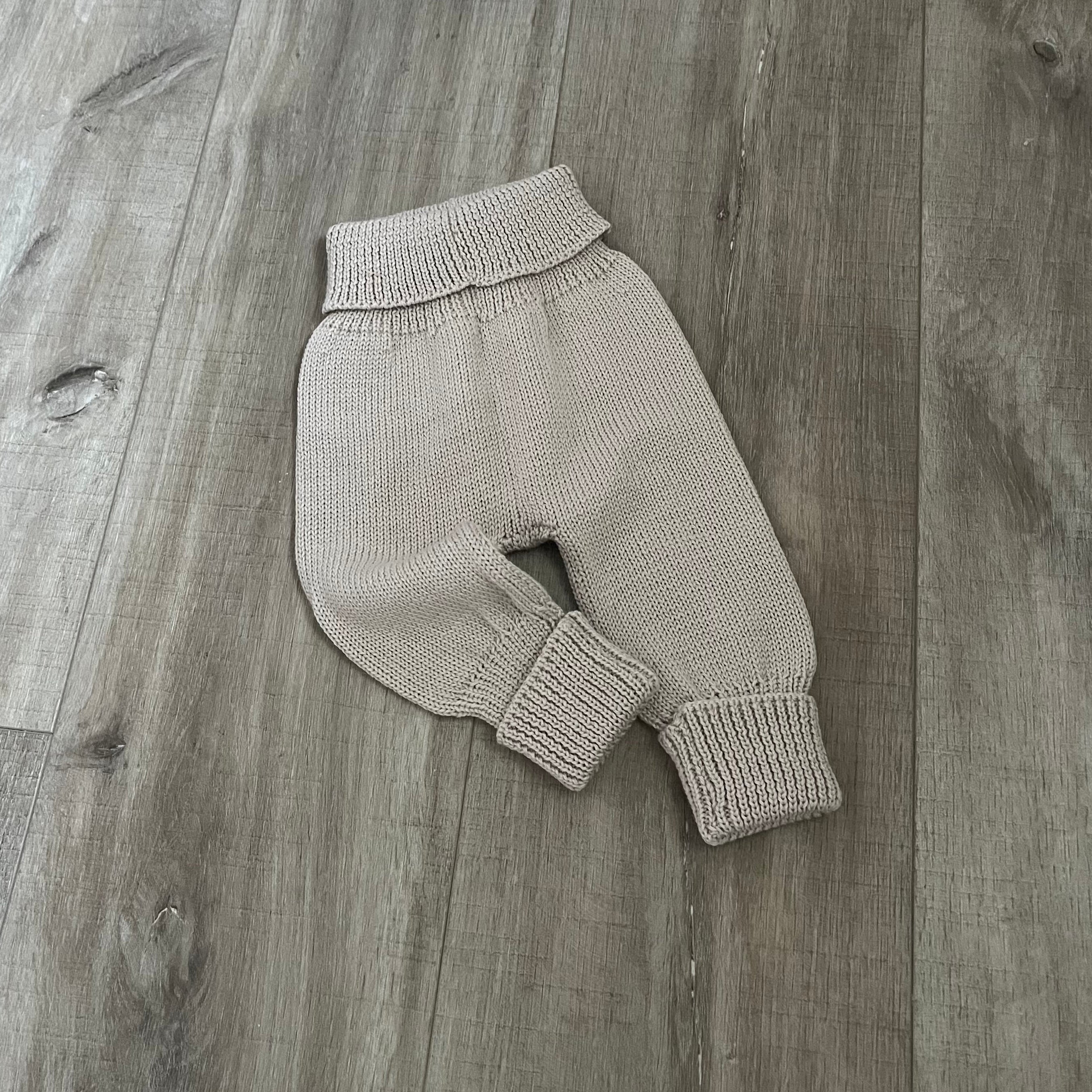 Baby sand colour knitted jodhpurs on wooden surface