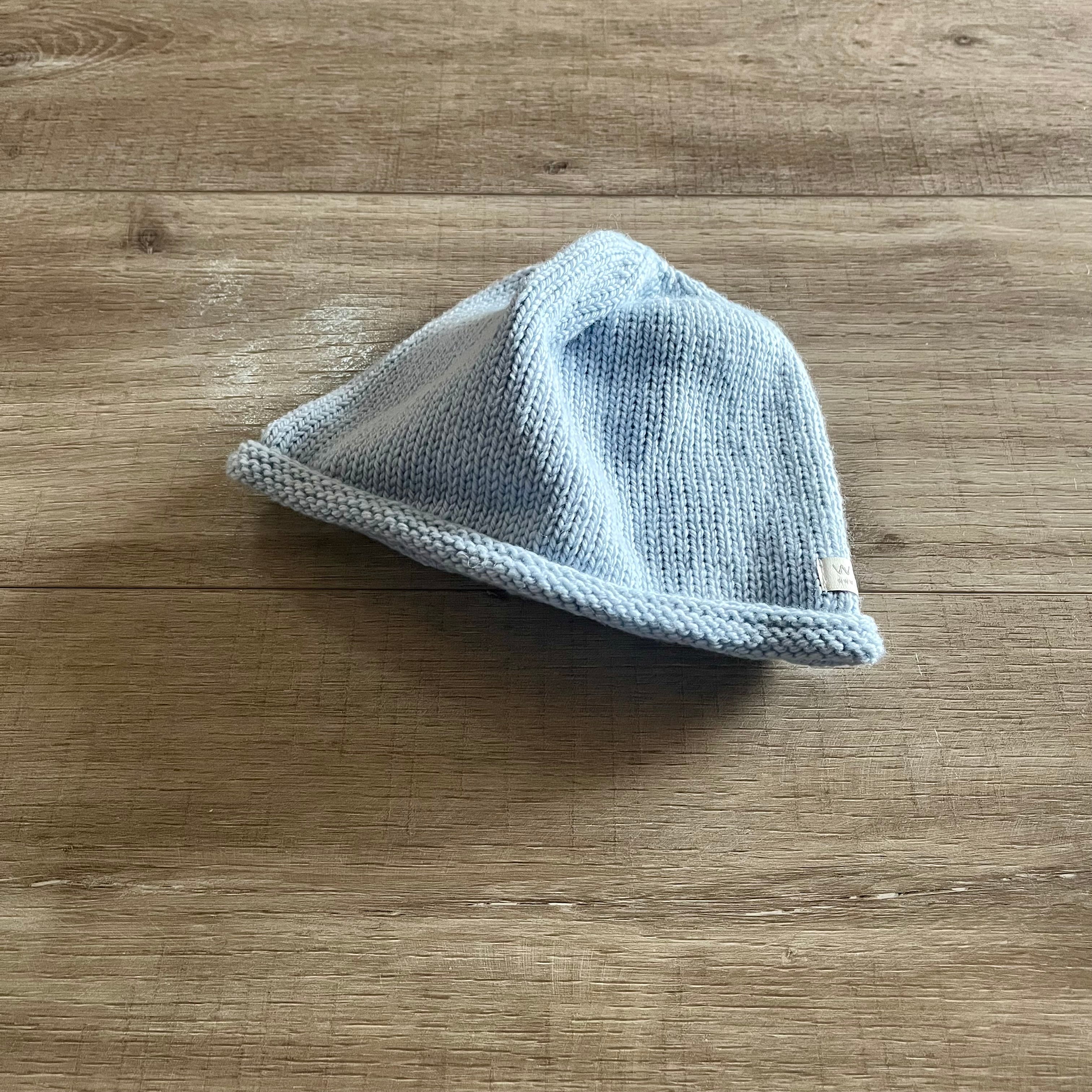 Knitted baby hat on a wooden surface