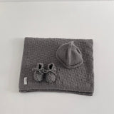 Knitted mushroom baby travel rug beanie and booties set on white shelf