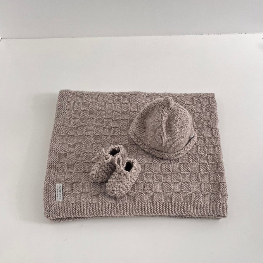 Knitted Oatmeal baby travel rug beanie and bootie set on white shelf