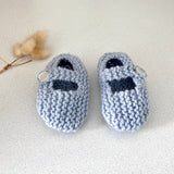 Pair of blue knitted baby shoes on a light background