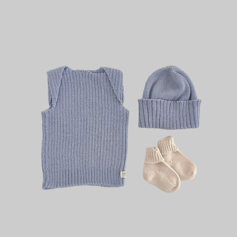 Baby blue vest, beanie, and socks on a light background