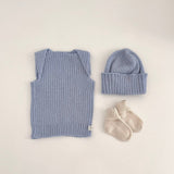 Baby blue vest, beanie, and socks on a light background