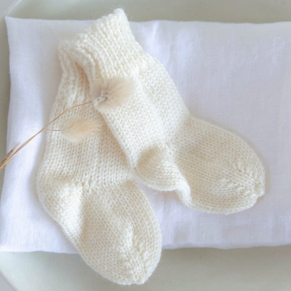 Merino baby socks on plate