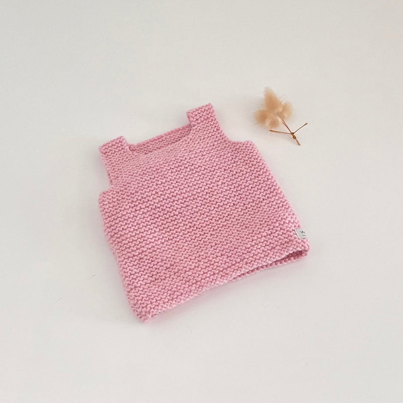 Pink knitted tank top on a light gray background