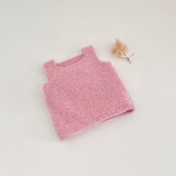 Pink knitted tank top on a light gray background