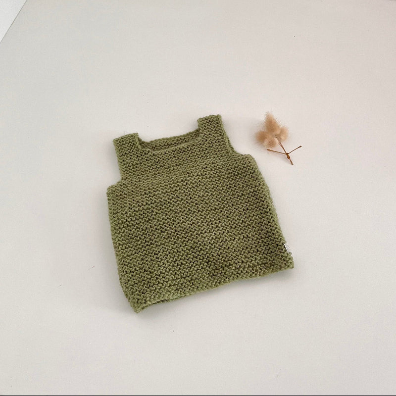 Pistachio knitted tank top on a white background with a dried flower.