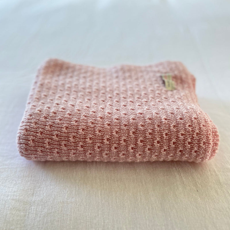 Blossom pink merino baby wrap on cotton sheet