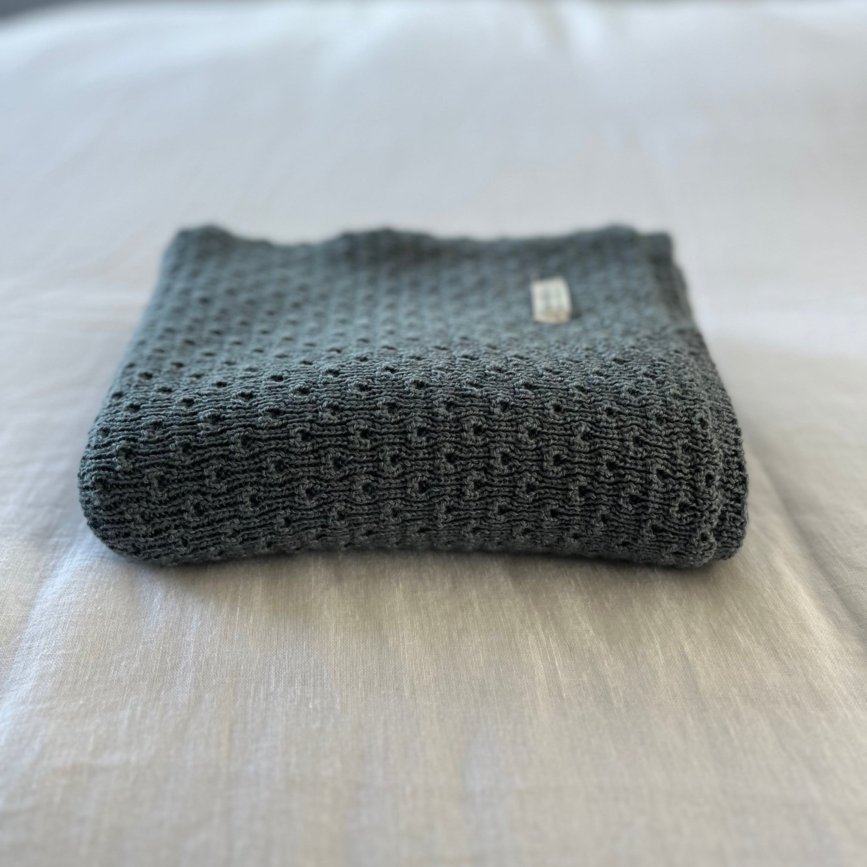Dusky blue textured baby wrap on a light-colored surface