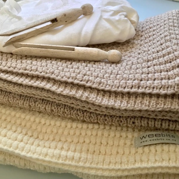 Merino bassinet blankets in oatmeal and ivory on table