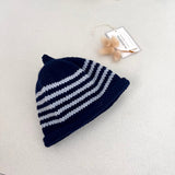 Navy and blue striped knit baby hat with a tag on a light grey background