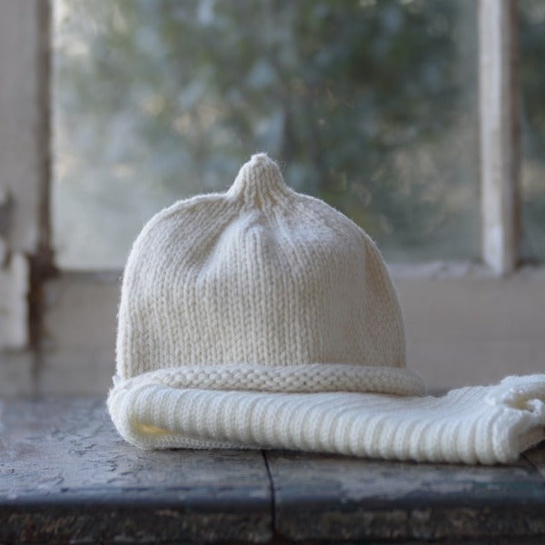 Natural baby beanie and vest on table