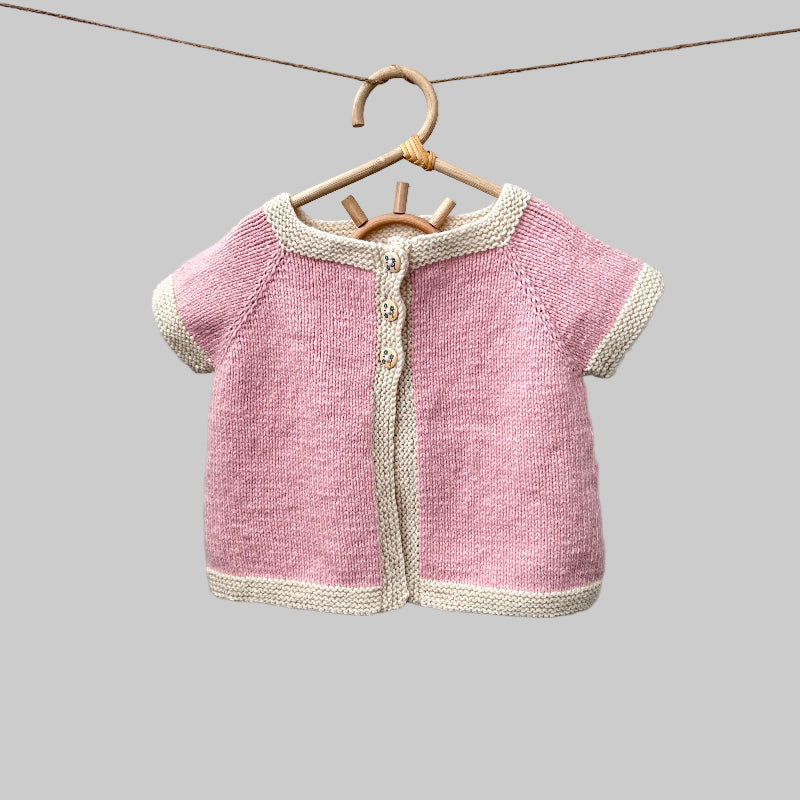 Chloe cardigan in pink with natural trim on hanger