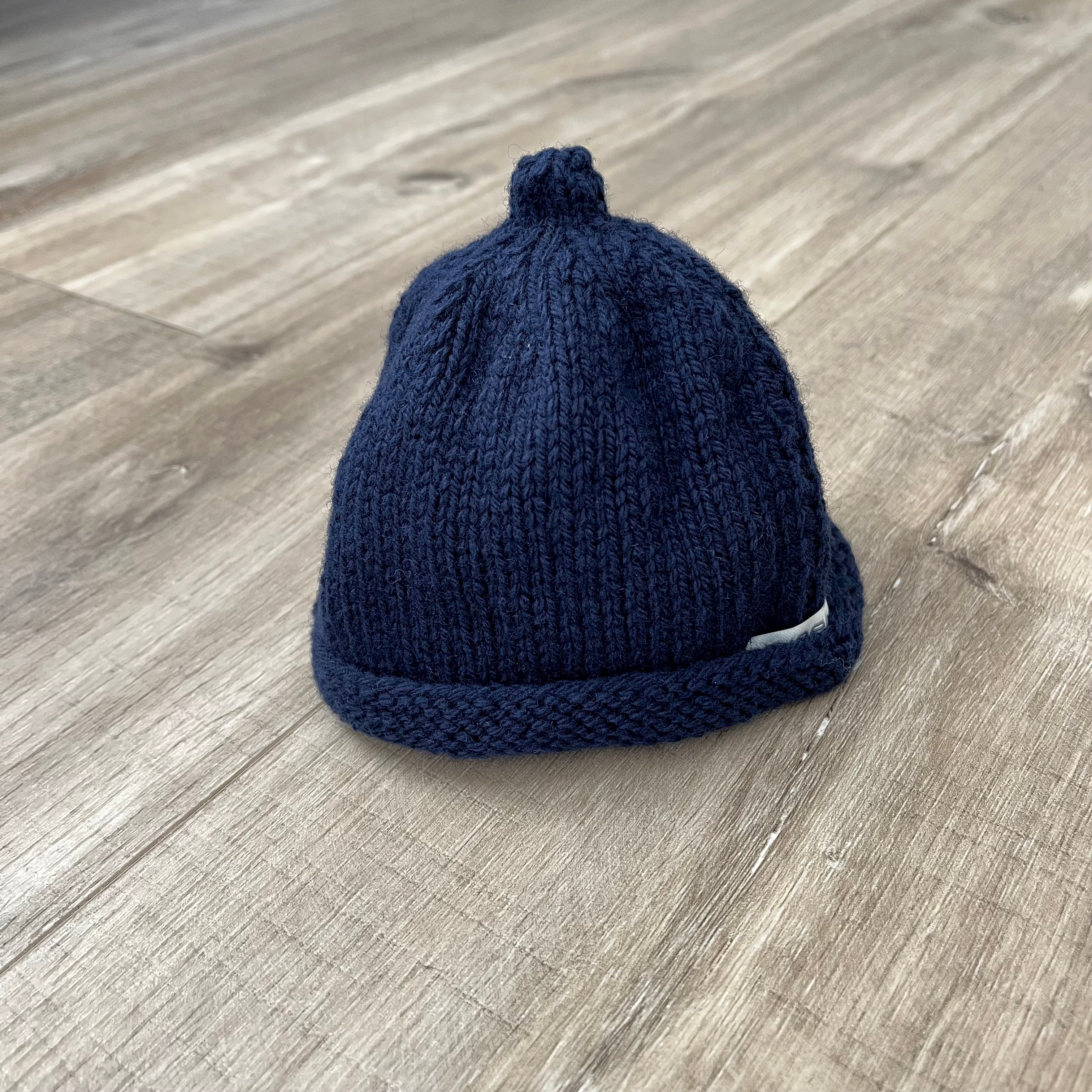 Baby-pixie-point-beanie-navy-colour-on-wooden-surface