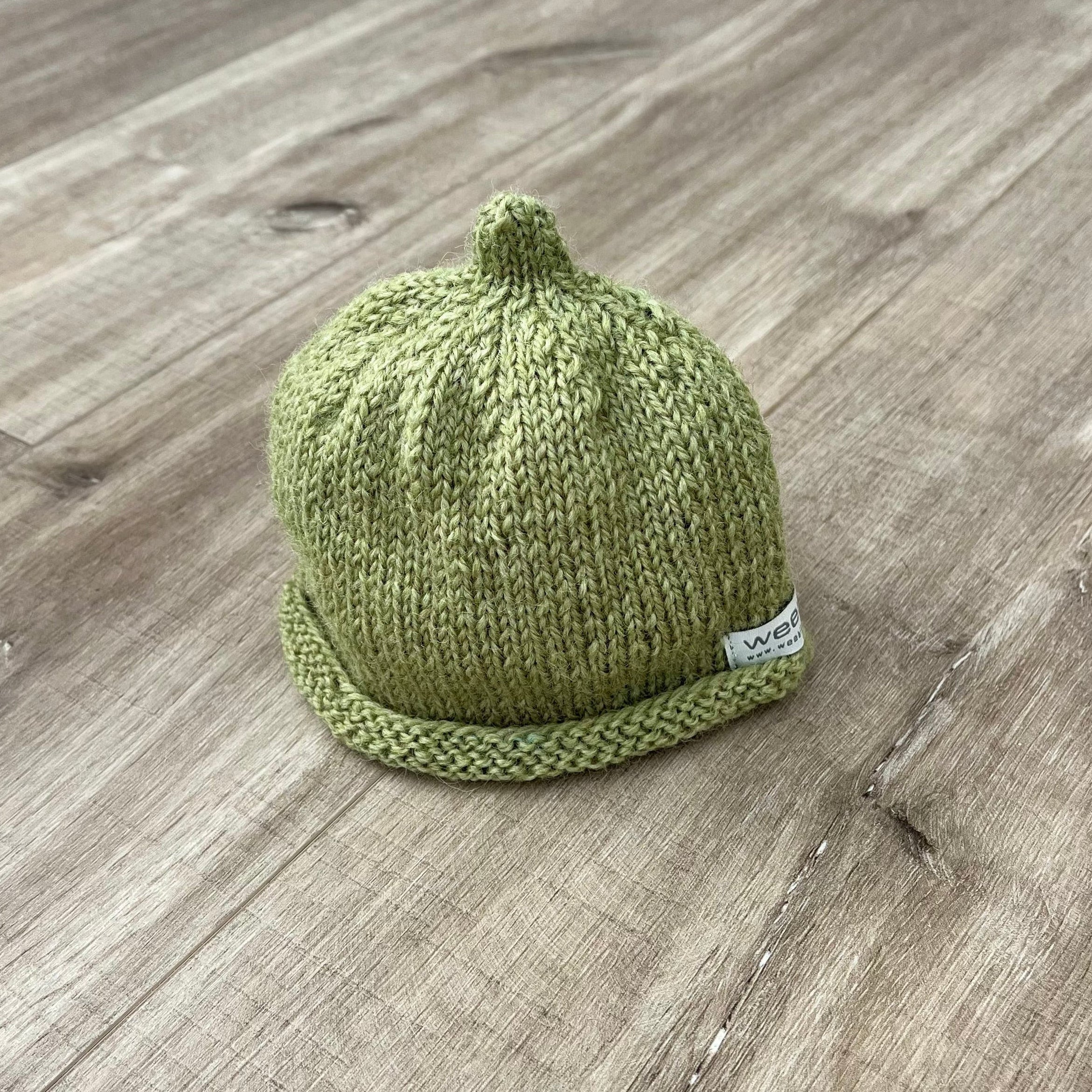 Baby-pixie-point-beanie-pistachio-colour-on-wooden-surface