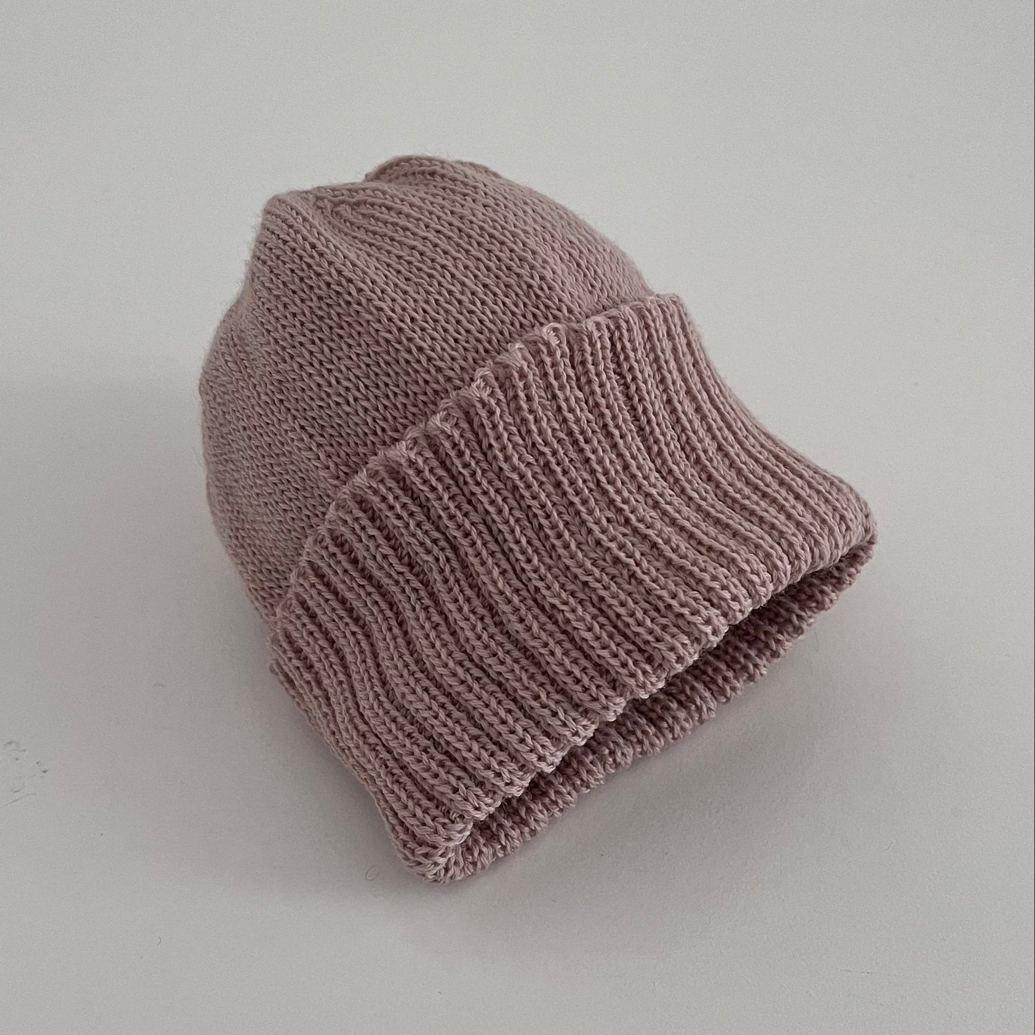 Knitted sandstone beanie on a light gray background