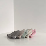 Pastel colour range of beanies on white shelf