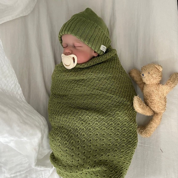 Sleeping baby in moss merino baby wrap