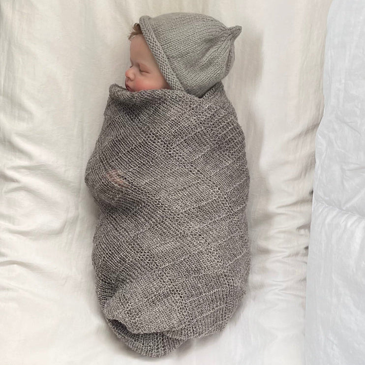 sleeping baby in knitted stansborough baby wrap and beanie