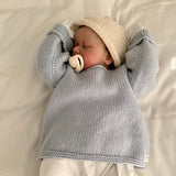 Sleeping baby wearing blue slouchy sweater