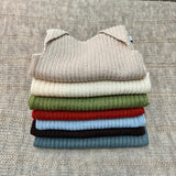 Stack of coloured merino baby singlets