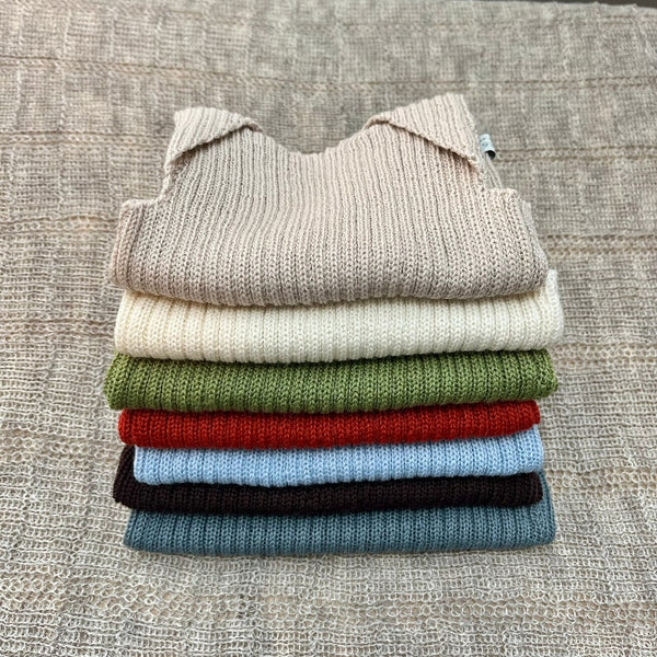 Stack of coloured merino baby singlets