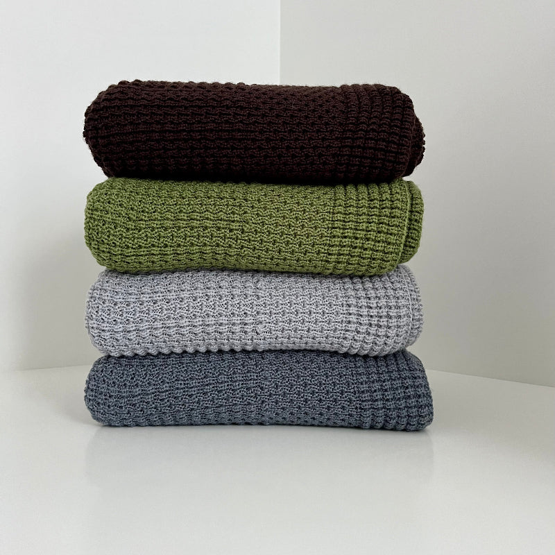 Stack of merino cot blanket nz made