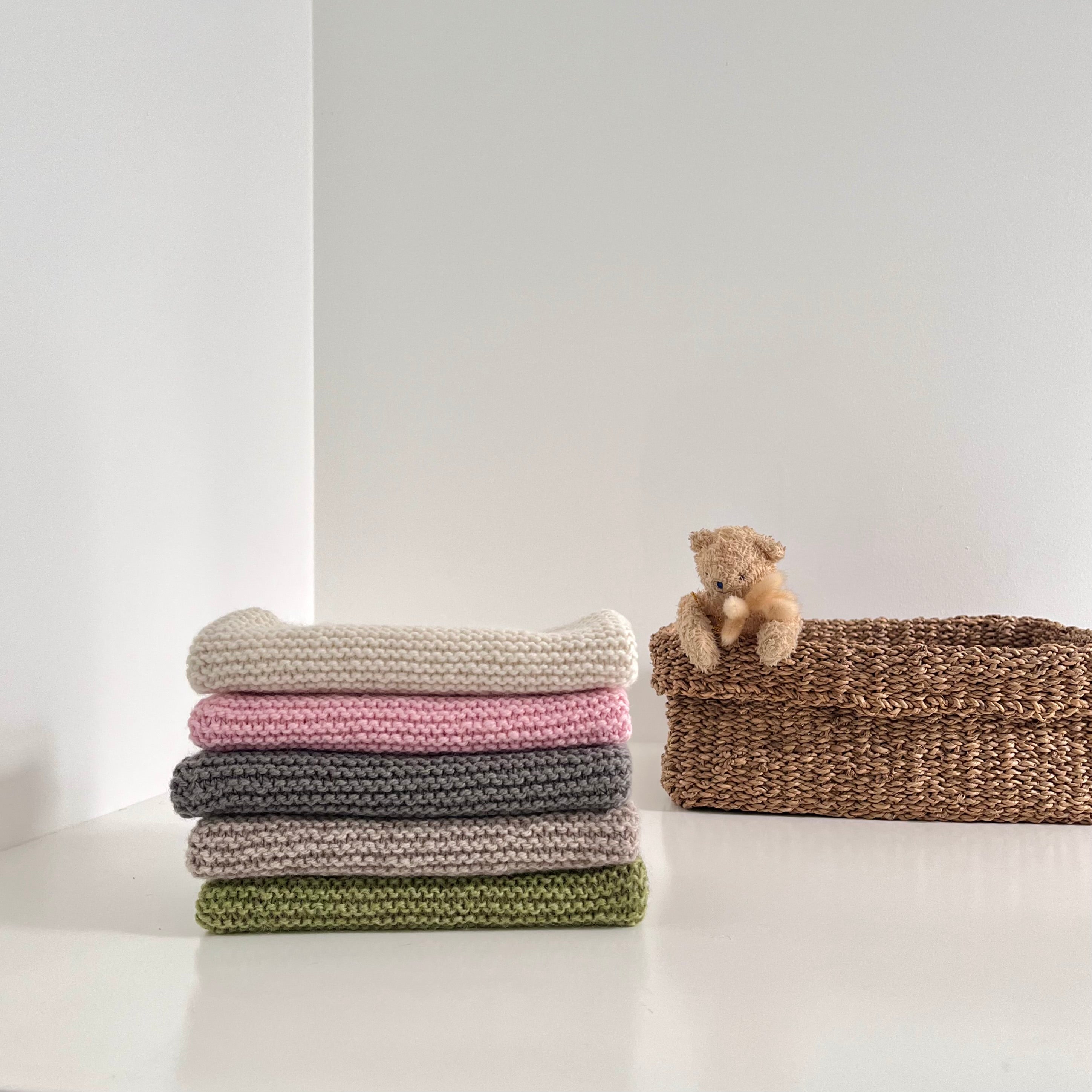 Stack of baby knitted merino tank tops