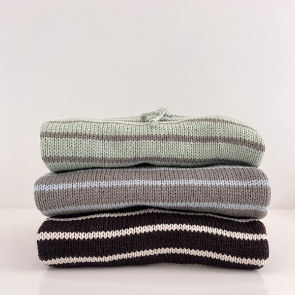 Three-striped-hoodies-front-on-sitting-on-white-bench