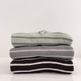 Three-striped-hoodies-front-on-sitting-on-white-bench