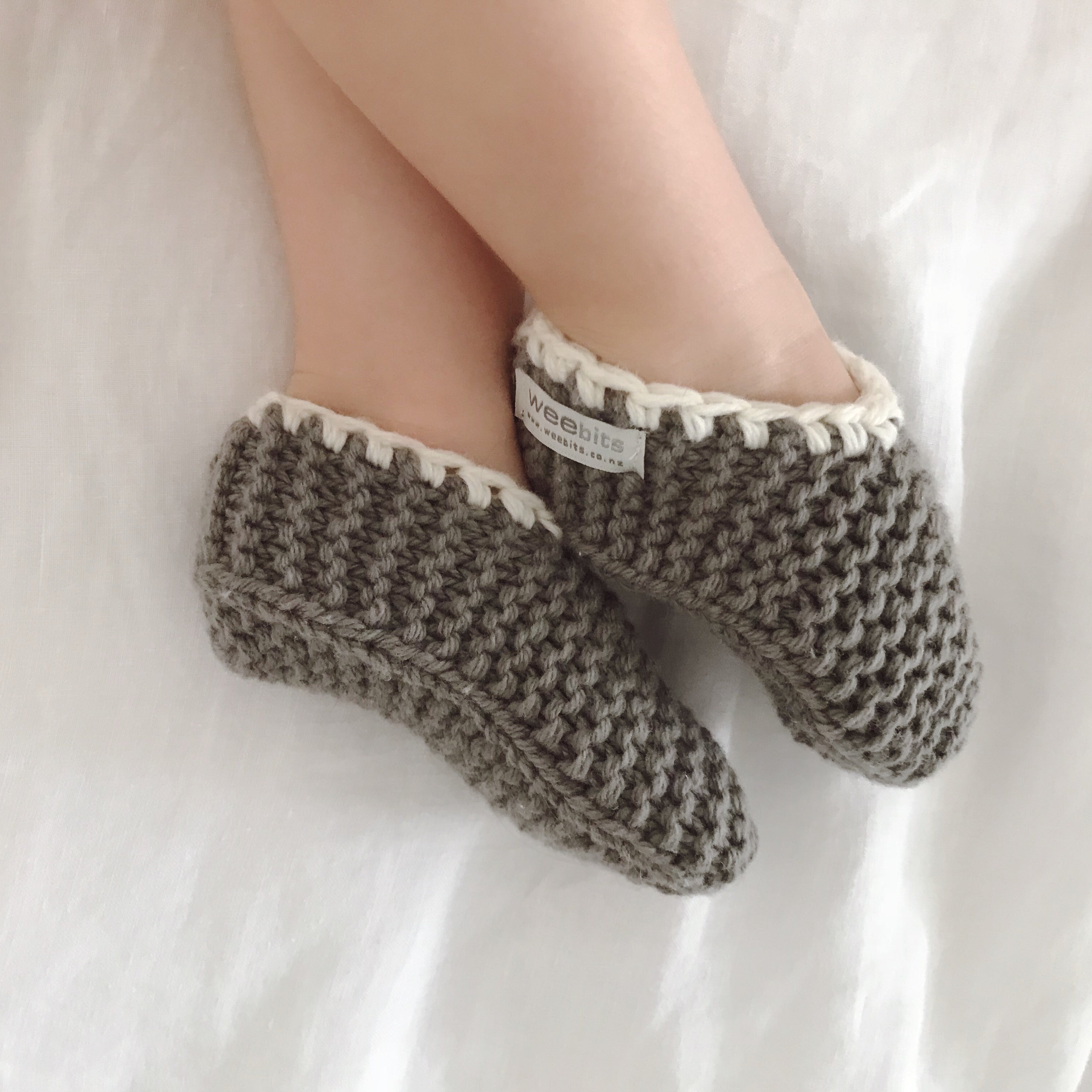 Toddler wearing a pair of merino mushroom slippers.