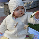 Baby in double breasted jacket and chunky hat