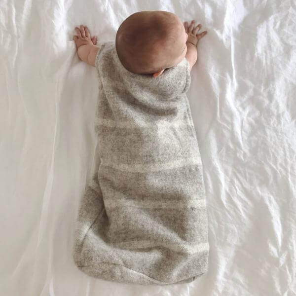 Baby in light grey sleeping bag