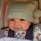 Baby in mint pompom hat