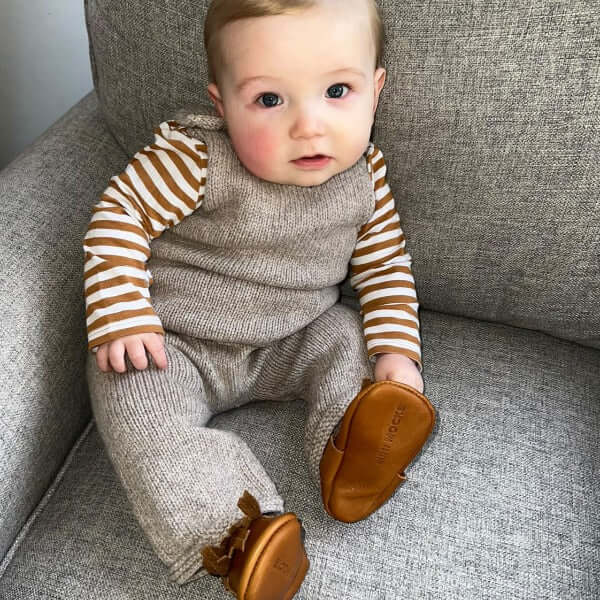 baby in oatmeal dungarees