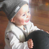Boy in baby waistcoat and pompom hat