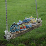 Colour range of multicolour beanies on a swing