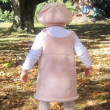 Infant in pink knitted baby dress
