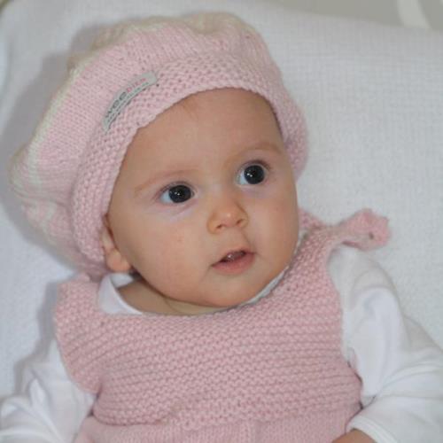 Infant wearing pink baby beret hat